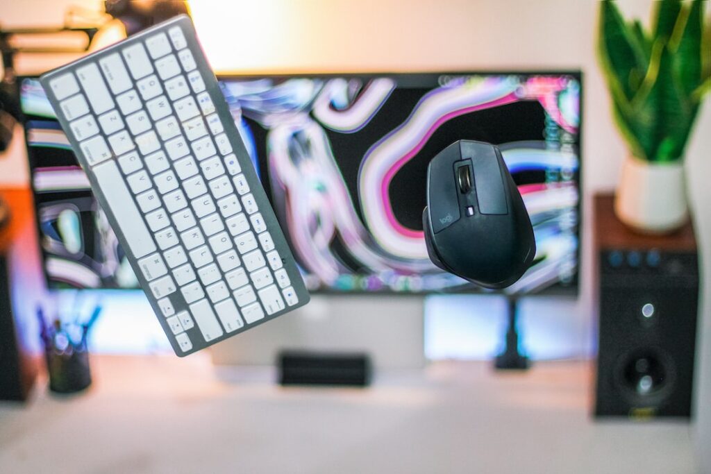 a computer keyboard and mouse on a desk