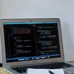 a laptop with a pen and paper on the table