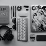 black corded headphones, silver MacBook, Apple wireless keyboard, and Apple Magic Mouse