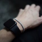 man wearing space gray Apple Watch with black Sports Band