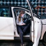 woman in white long sleeve shirt sitting on white car